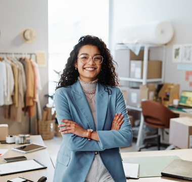 Frau steht mit verschränkten Händen in einem Büro