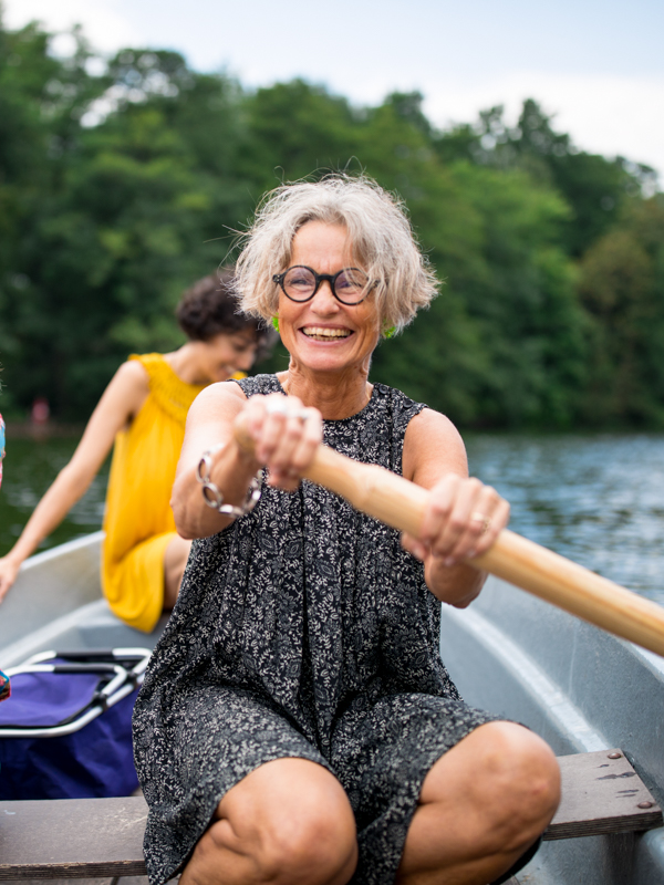 Eine ältere Dame sitzt in einem Ruderboot.